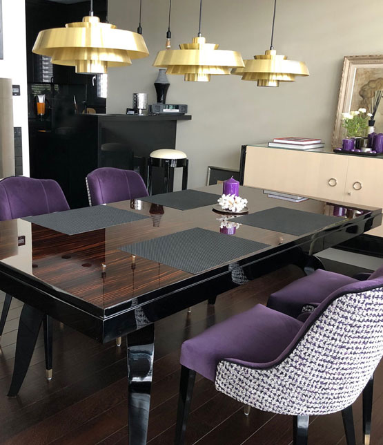 Foto mit Esstisch und lila bezogenen Stühlen und Deckenleuchten in Messing